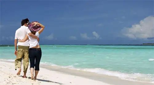 Pareja de espaldas paseando por una playa Imagen de una pareja de espaldas paseando por una playa