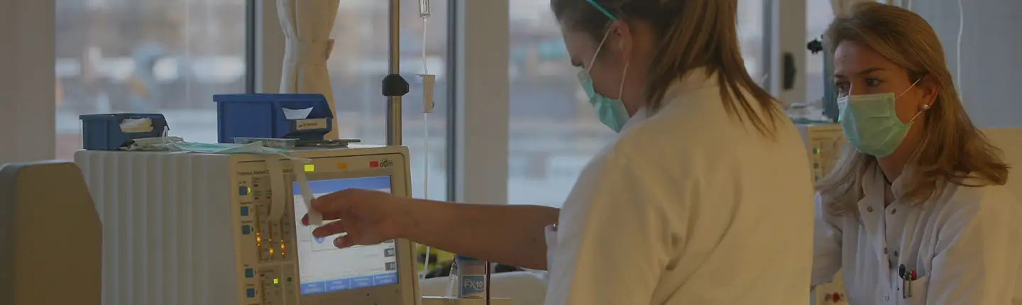 Dos especialistas observan los parámetros de una máquina de diálisis.<br/><br/>