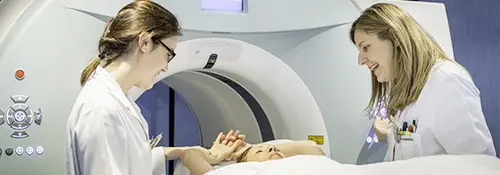 Diagnóstico en el PET. Medicina Nuclear. Clínica Universidad de Navarra Imagen de 2 doctoras atendiendo a una paciente en el PET de la Clínica Universidad de Navarra.